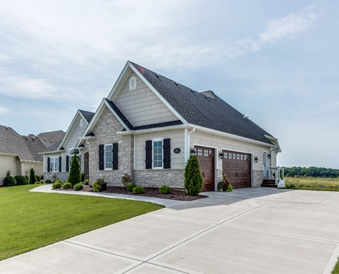 A residential property showcasing a driveway alongside a well-maintained grassy area, enhancing its curb appeal